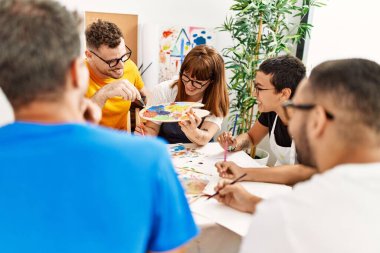 Resim stüdyosunda çizim yapan bir grup insan..