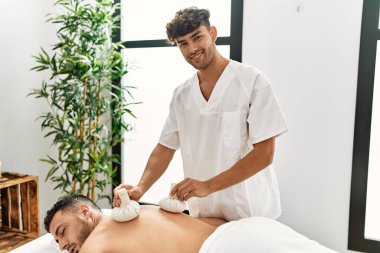 İki İspanyol fizyoterapist ve hasta masaj yapıyor. Güzellik merkezinde Tayland çantaları kullanıyorlar.