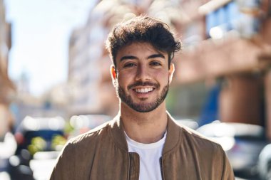 Sokakta kendinden emin gülümseyen İspanyol genç adam.