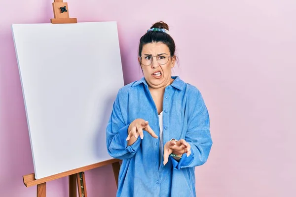 Young Hispanic Woman Standing Painter Easel Stand Disgusted Expression Displeased — ストック写真