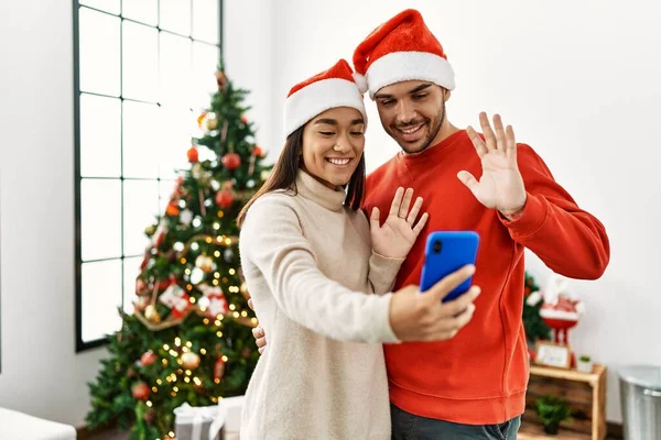Young Hispanic Couple Wearing Christmas Hat Having Video Call Smartphone — Stok fotoğraf