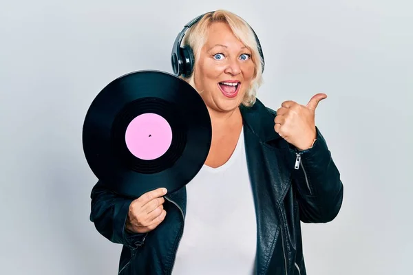 Middle Age Blonde Woman Holding Vinyl Disc Using Headphones Pointing — Foto de Stock