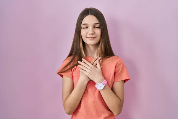 Teenager Girl Standing Pink Background Smiling Hands Chest Closed Eyes — Stockfoto