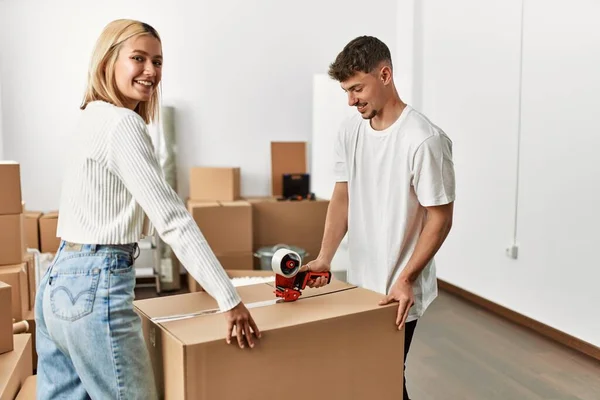 Young Caucasian Couple Smiling Happy Closing Box Using Packing Tape — Stock Photo, Image