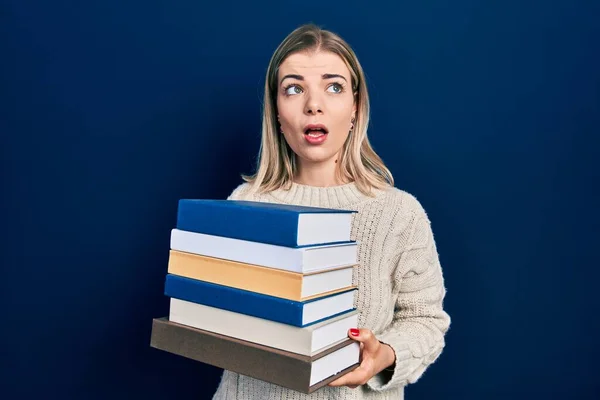 Beautiful Caucasian Woman Holding Pile Books Shock Face Looking Skeptical — Stock Photo, Image