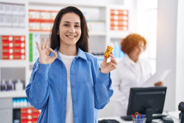 Young Brunette Woman Holding Pills Pharmacy Doing Sign Fingers Smiling — Fotografia de Stock