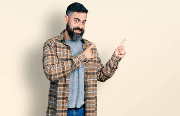 髭を生やしたヒスパニック系の男はカジュアルなシャツを着て笑顔とカメラを見て2本の手と指で側面を指して — ストック写真