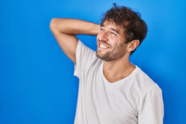 Hispanic Young Man Standing Blue Background Smiling Confident Touching Hair — Stock Photo, Image