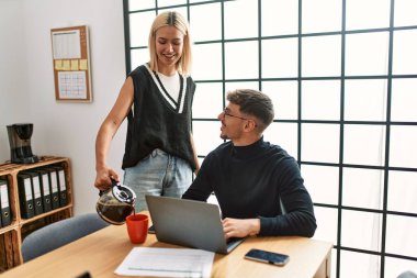 Ofiste çalışırken ve kahve içerken gülümseyen iki iş adamı..