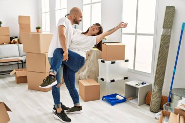 Genç İspanyol çift gülümsüyor yeni evinde mutlu dans ediyor.