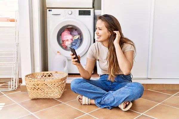 Menina Hispânica Jovem Usando Smartphone Espera Máquina Lavar Casa — Fotografia de Stock