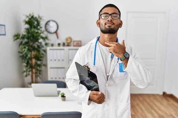 Young Indian Man Wearing Doctor Uniform Stethoscope Cutting Throat Hand — Stok fotoğraf