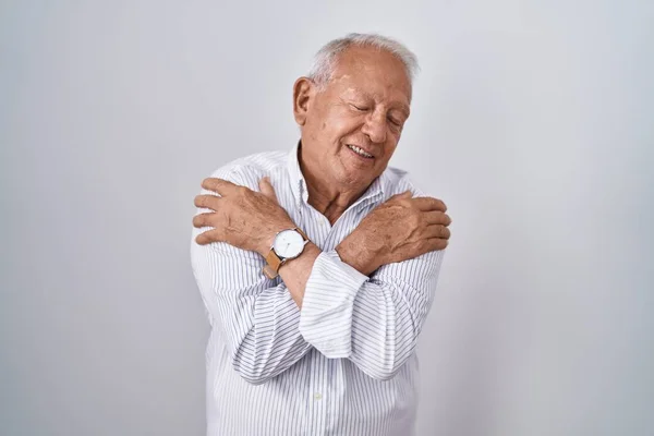 Senior Man Grey Hair Standing Isolated Background Hugging Oneself Happy — Stock fotografie