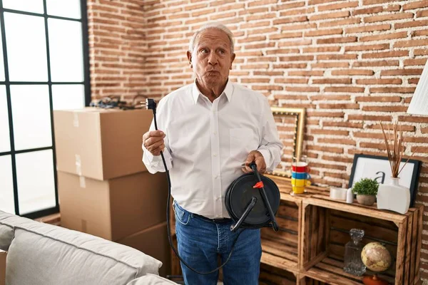 Senior Man Grey Hair Holding Extension Plug Smiling Looking Side —  Fotos de Stock