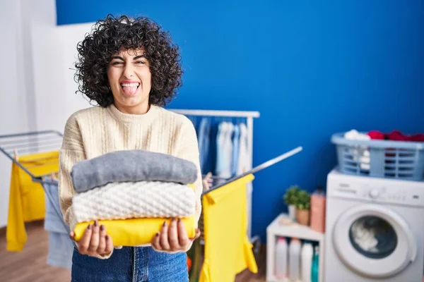 Young Brunette Woman Curly Hair Holding Clean Laundry Sticking Tongue — Foto Stock