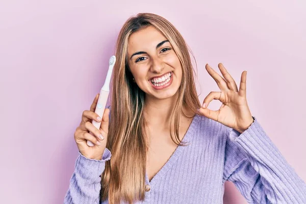 Mooie Spaanse Vrouw Met Elektrische Tandenborstel Doen Teken Met Vingers — Stockfoto