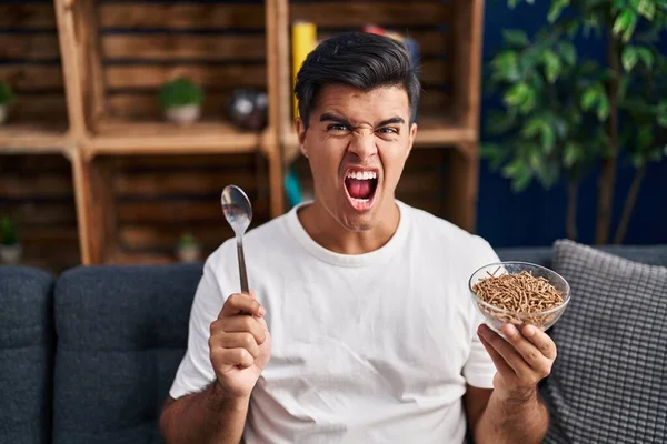 Uomo Ispanico Mangiare Cereali Integrali Sani Con Cucchiaio Arrabbiato Pazzo — Foto Stock