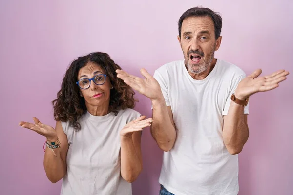 Middle Age Hispanic Couple Together Pink Background Clueless Confused Expression — Fotografia de Stock