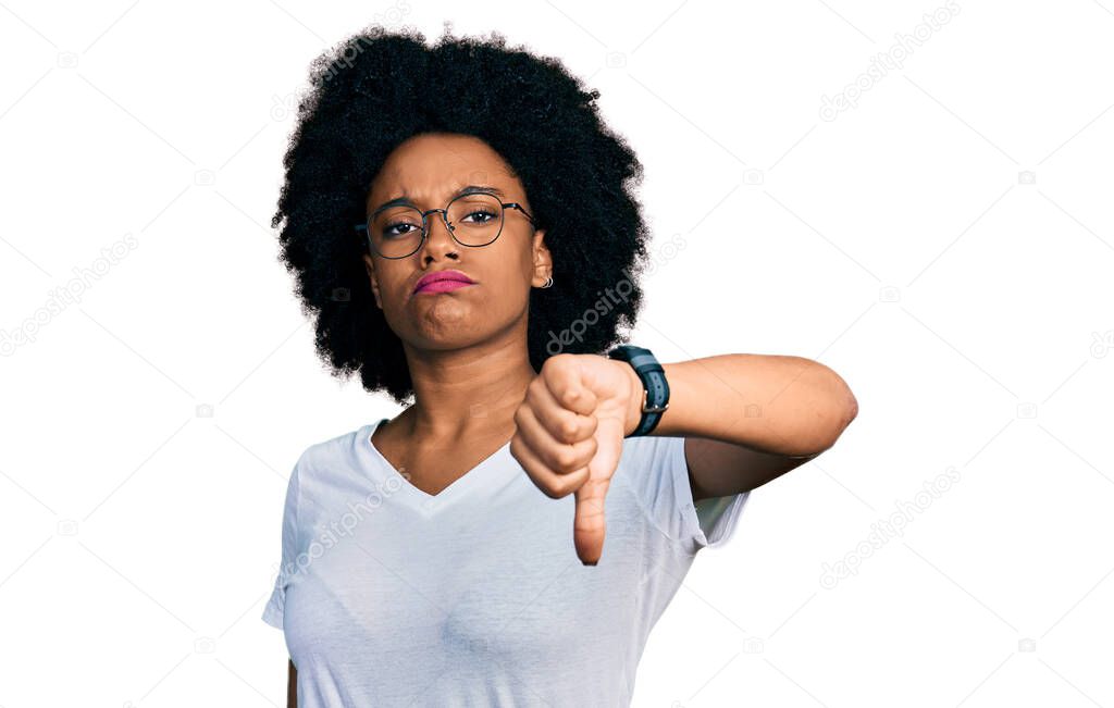 Young african american woman wearing casual white t shirt looking unhappy and angry showing rejection and negative with thumbs down gesture. bad expression. 