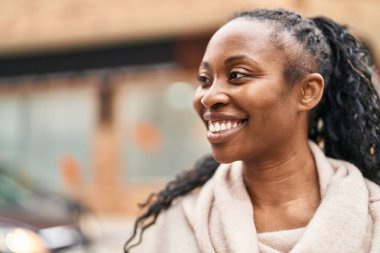 Sokakta kendine güvenen Afrikalı Amerikalı kadın gülümsüyor