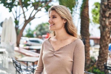 Sokakta kendine güvenen genç sarışın kadın gülümsüyor