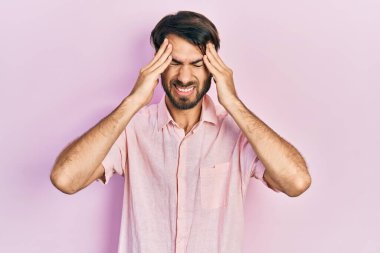 İspanyol asıllı genç adam gündelik giysiler giyiyor. Baş ağrısı çekiyor. Acı ve migren yüzünden çaresiz ve stresli. Eller başının üstünde.. 