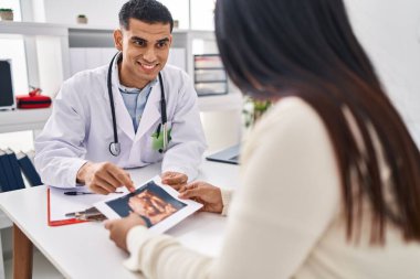 Genç Latin çift doktor ve hasta bebek ekografisi klinikte görülüyor.