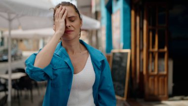 Young woman stressed standing at street