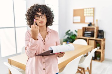 Young middle eastern woman wearing business style at office showing middle finger, impolite and rude fuck off expression 