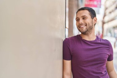 Young man smiling confident looking to the side at street