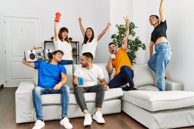 Mutlu bir şekilde gülümseyen ve dans eden bir grup genç arkadaş..