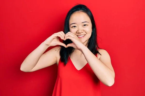 年轻的中国女孩穿着休闲装 带着爱的笑容用手做心形符号 浪漫的概念 — 图库照片