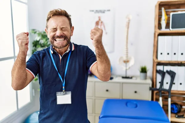 Middle Age Physiotherapist Man Working Pain Recovery Clinic Excited Success — Fotografia de Stock