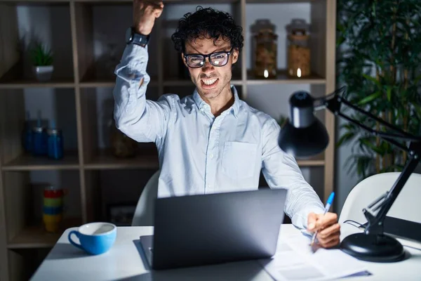 Hispanic Man Working Office Night Angry Mad Raising Fist Frustrated — Foto Stock