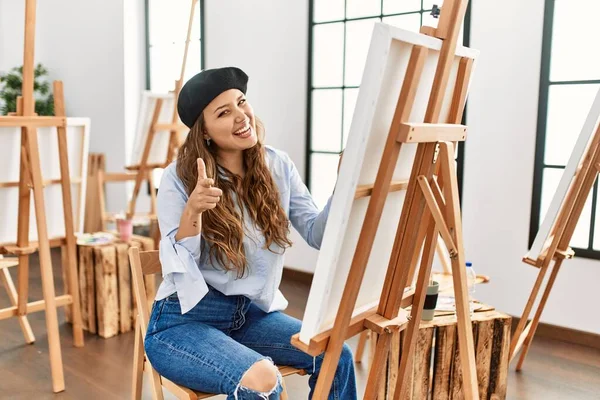 Young Hispanic Artist Woman Painting Canvas Art Studio Pointing Fingers — Stock Photo, Image
