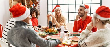 Bir grup genç arkadaş yılbaşı yemeğini evde masada yiyorlar..