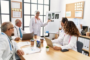 Bir grup orta yaşlı doktor klinikteki bir tıbbi toplantıda tartışıyorlar..