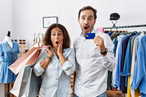 Hispanic Middle Age Couple Holding Shopping Bags Credit Card Afraid — ストック写真