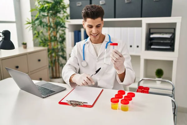 Young Hispanic Man Wearing Doctor Uniform Pointing Analysis Test Tube — Foto de Stock