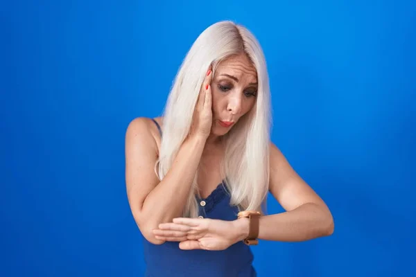 Λευκή Γυναίκα Στέκεται Πάνω Από Μπλε Φόντο Κοιτάζοντας Την Ώρα — Φωτογραφία Αρχείου