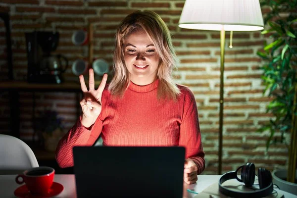 Blonde Woman Using Laptop Night Home Showing Pointing Fingers Number — ストック写真