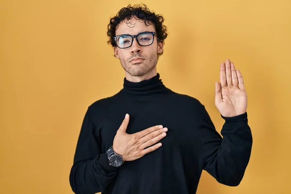 Hispanic Man Standing Yellow Background Swearing Hand Chest Open Palm — ストック写真