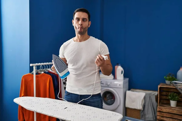 Young Hispanic Man Beard Ironing Clothes Home Making Fish Face — Foto de Stock
