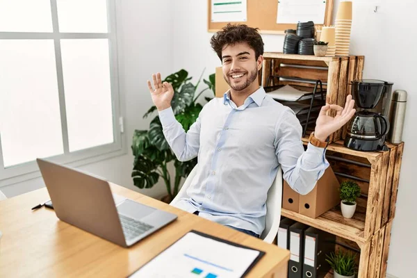 Young hispanic businessman relaxed meditating with yoga exercise at the office.