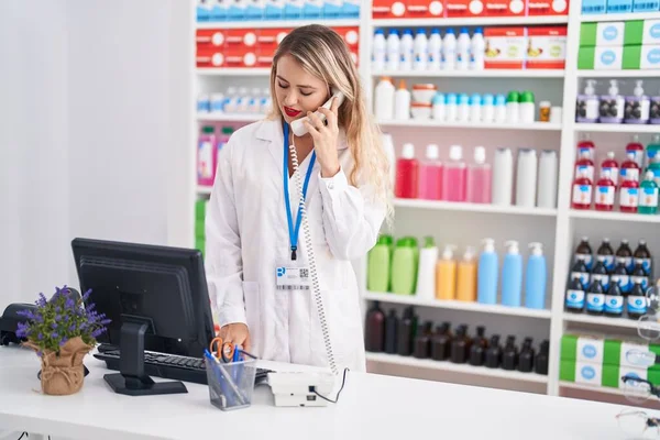 Young Beautiful Hispanic Woman Pharmacist Talking Telephone Using Computer Pharmacy — Foto Stock