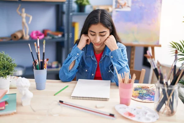 Young Hispanic Girl Artist Sitting Desk Doubt Expression Art Studio — Stock Photo, Image
