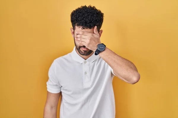 Arab Man Standing Yellow Background Covering Eyes Hand Looking Serious — Stock Photo, Image