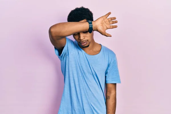 年轻的非洲裔美国人穿着休闲的蓝色T恤 用胳膊蒙住眼睛 看起来严肃而忧郁 躲藏和拒绝的概念 — 图库照片