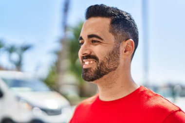 Sokakta kendinden emin gülümseyen İspanyol genç adam.