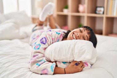 Genç ve güzel İspanyol kadın yatak odasında yastığa sarılıyor.